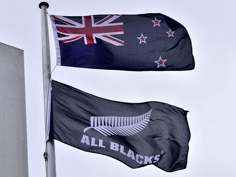 Die Flaggen von Neuseeland und die Flagge des All Blacks Rugby Teams wehen im Wind.