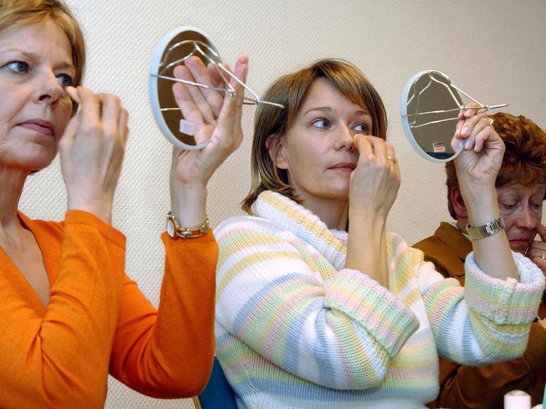 An Krebs erkrankte Patientinnen schminken sich während des Kurses "Freude am Leben" im St.-Johannes-Hospital in Dortmund (Foto vom 16.02.2005). Infolge der Krankheit und der Behandlung durch Strahlen- oder Chemotherapie fallen bei vielen Betroffenen die Haare aus, die Haut verändert sich und wird empfindlicher. Make-up und die richtigen Schminktipps sollen den Frauen helfen, sich schön zu fühlen und "Freude am Leben" zurückzugewinnen.