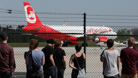 Am Flughafen Rostock-Lage startet eine Maschine mit abgeschobenen Asylbewerbern, Aktivisten schauen hinter einem Zaun zu.