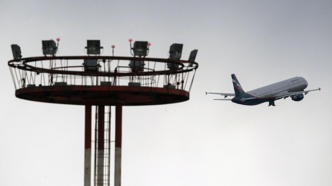 Ein Flugzeug fliegt am Tower vorbei.