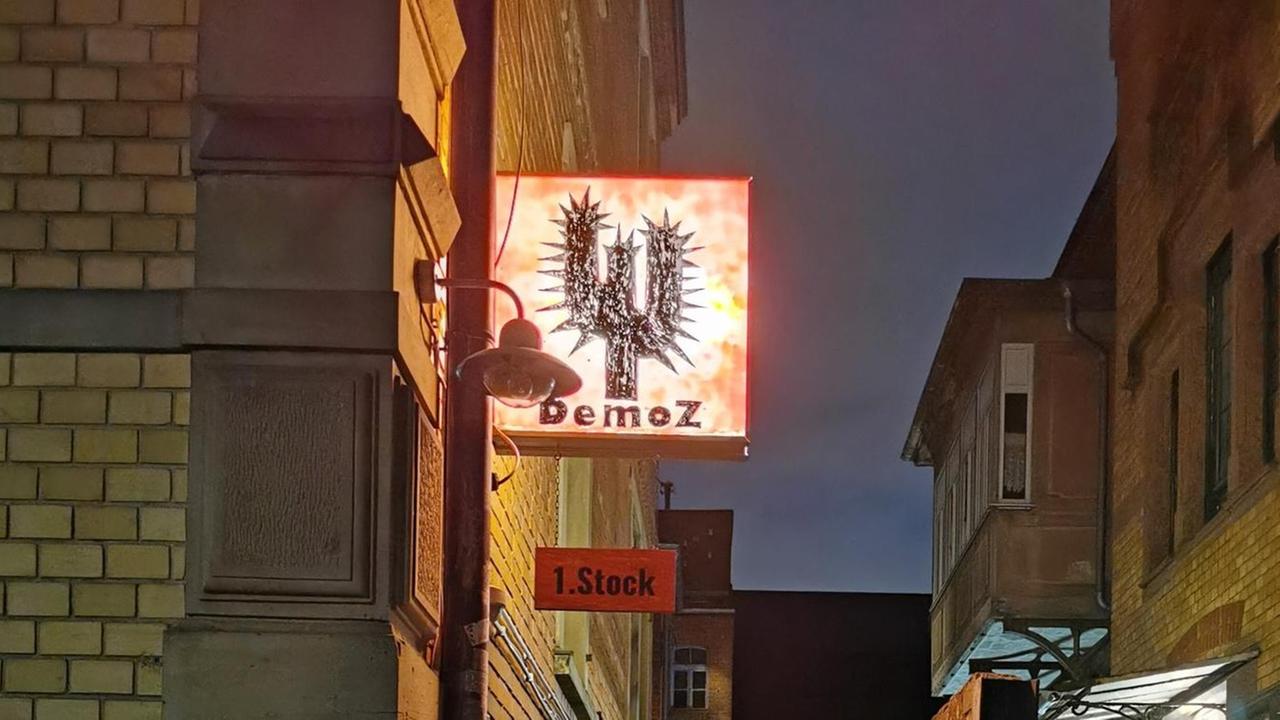 Das erleuchtete Schild des DemoZ Vereins in Ludwigsburg: Schwarzer stachliger Kaktus mit der DemoZ-Schrift darunter. Das erleuchtete Schild des DemoZ Vereins in Ludwigsburg: Schwarzer stachliger Kaktus mit der DemoZ-Schrift darunter.