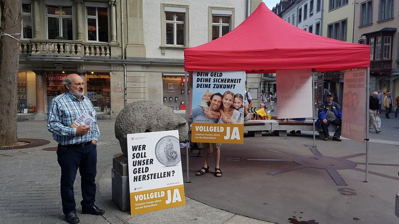 Info-Stand der Schweizer Vollgeld-Initiative am Bärenplatz in St. Gallen. Reinhold Harringer (links) hält einen Stapel Broschüren in der Hand. Aufnahme vom 02.06.2018 Info-Stand der Schweizer Vollgeld-Initiative am Bärenplatz in St. Gallen. Reinhold Harringer (links) hält einen Stapel Broschüren in der Hand. Aufnahme vom 02.06.2018