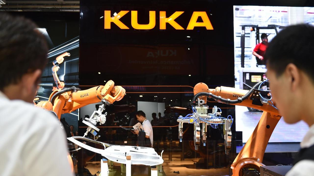 Besucher am Messe-Stand des Unternehmens Kuka während der "China International Industry Fair 2015" in Shanghai. Besucher am Messe-Stand des Unternehmens Kuka während der "China International Industry Fair 2015" in Shanghai.