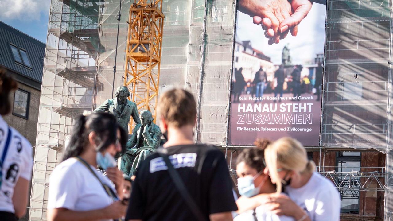 Ein neues Banner mit der Aufschrift "Kein Platz für Rassismus und Gewalt - Hanau steht zusammen für Respekt, Toleranz und Zivilcourage" hängt an der Fassade des Rathauses vor dem Gebrüder-Grimm-Denkmal. Ein neues Banner mit der Aufschrift "Kein Platz für Rassismus und Gewalt - Hanau steht zusammen für Respekt, Toleranz und Zivilcourage" hängt an der Fassade des Rathauses vor dem Gebrüder-Grimm-Denkmal.