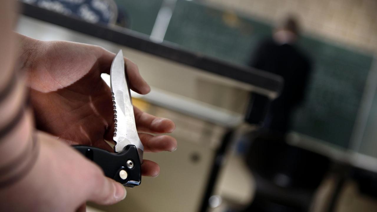 Eine Schülerin zeigt während des Unterrichts einer Mitschülerin ihr Klappmesser Eine Schülerin zeigt während des Unterrichts einer Mitschülerin ihr Klappmesser