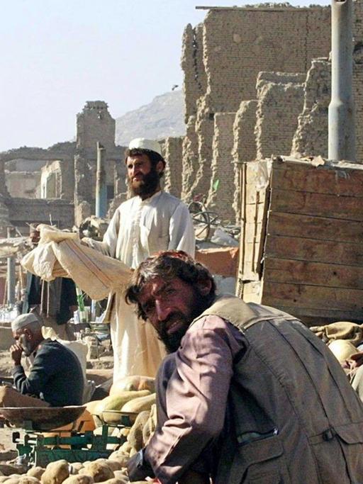 Das Archivbild vom 20.11.2001 zeigt einen Gemüseverkäufer auf einem Basar in Kabul. Auf den Märkten gibt es alles, Kinder fahren Gemüse und Obst auf Karren durch die ganze Stadt, doch es ist einfach zu teuer, damit es die Afghani kaufen. Berge von Schutt säumen die Straßenzüge. (zu dpa Korr-Bericht "Wir würden gerne hoffen - Kampf ums Überleben prägt Leben in Kabul).