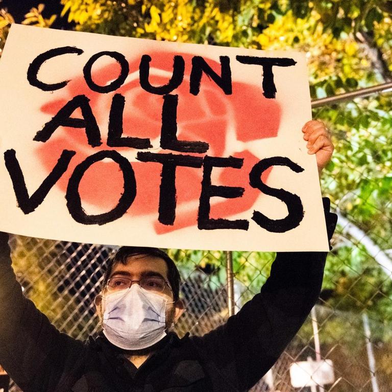 Demonstrant mit "Count all votes"-Plakat am Abend der Präsidentschaftswahl auf der Black Lives Matter Plaza in Washington D.C.