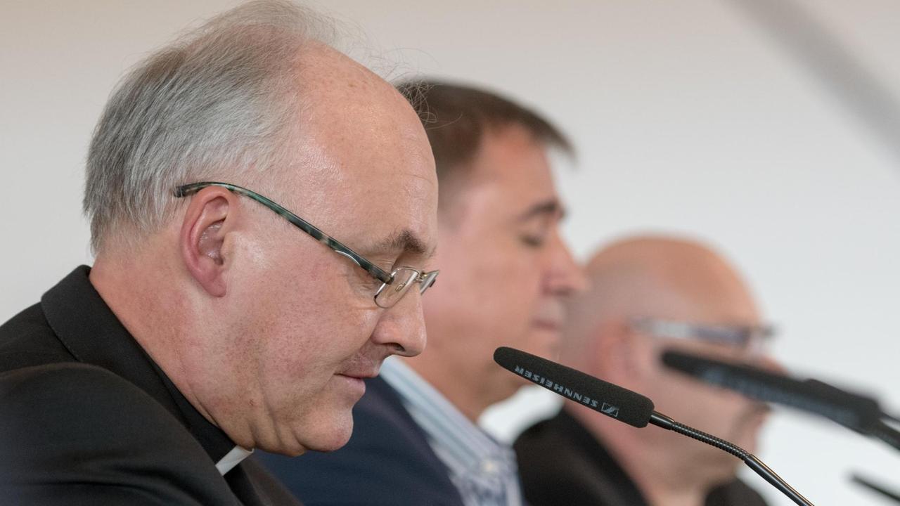 Der Regensburger Bischof Rudolf Voderholzer (l) spricht am 12.10.2016 in Regensburg (Bayern) während einer Pressekonferenz neben den Vertretern der Missbrauchsopfer, Peter Schmitt und Alexander Probst (r) zu den Journalisten.