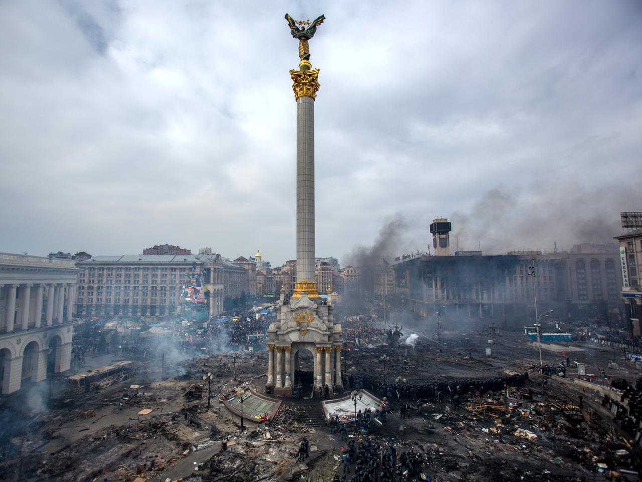Der Maidan-Platz in Kiew. Verbranntes Material und Trümer liegen überall herum, Rauchschwaden sind zu sehen.