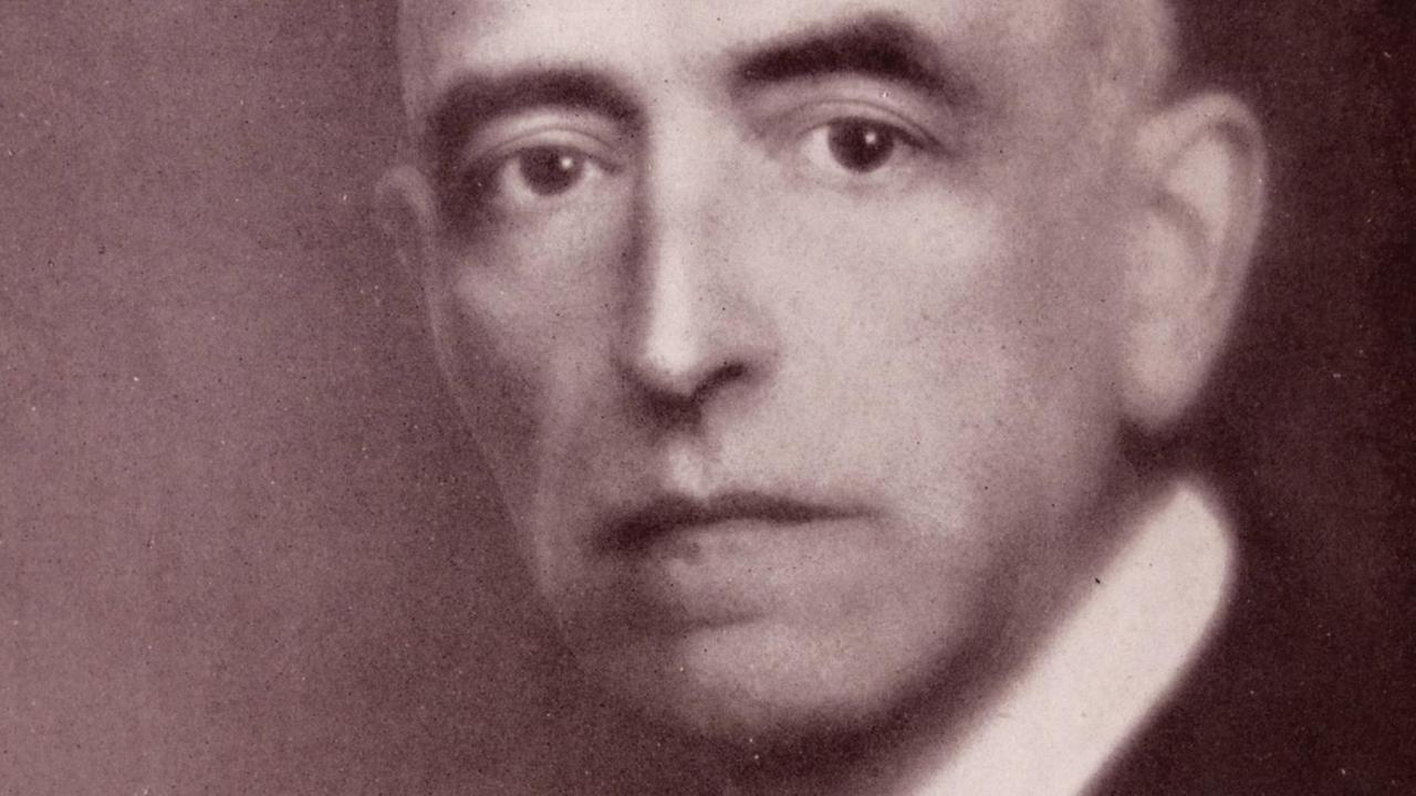 Eine historische Fotografie zeigt den Komponisten Manuel de Falla, der ernst in die Kamera blickt. Eine historische Fotografie zeigt den Komponisten Manuel de Falla, der ernst in die Kamera blickt.