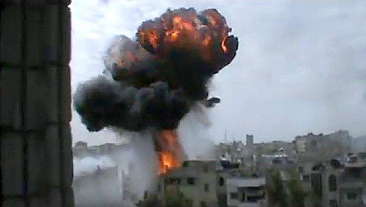 Der Blick fällt aus dem Fenster auf eine gewaltige Rauch- und Feuerwolke inmitten von Gebäuden, in der syrischen Stadt Homs in Syrien wurde auch während der Waffenruhe geschossen. Der Blick fällt aus dem Fenster auf eine gewaltige Rauch- und Feuerwolke inmitten von Gebäuden, in der syrischen Stadt Homs in Syrien wurde auch während der Waffenruhe geschossen.