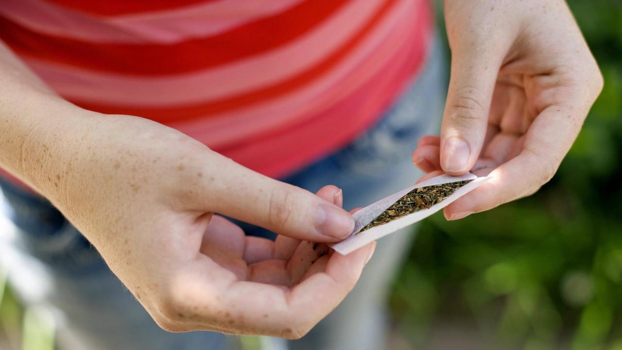 Eine Jugendliche dreht sich einen Joint Eine Jugendliche dreht sich einen Joint