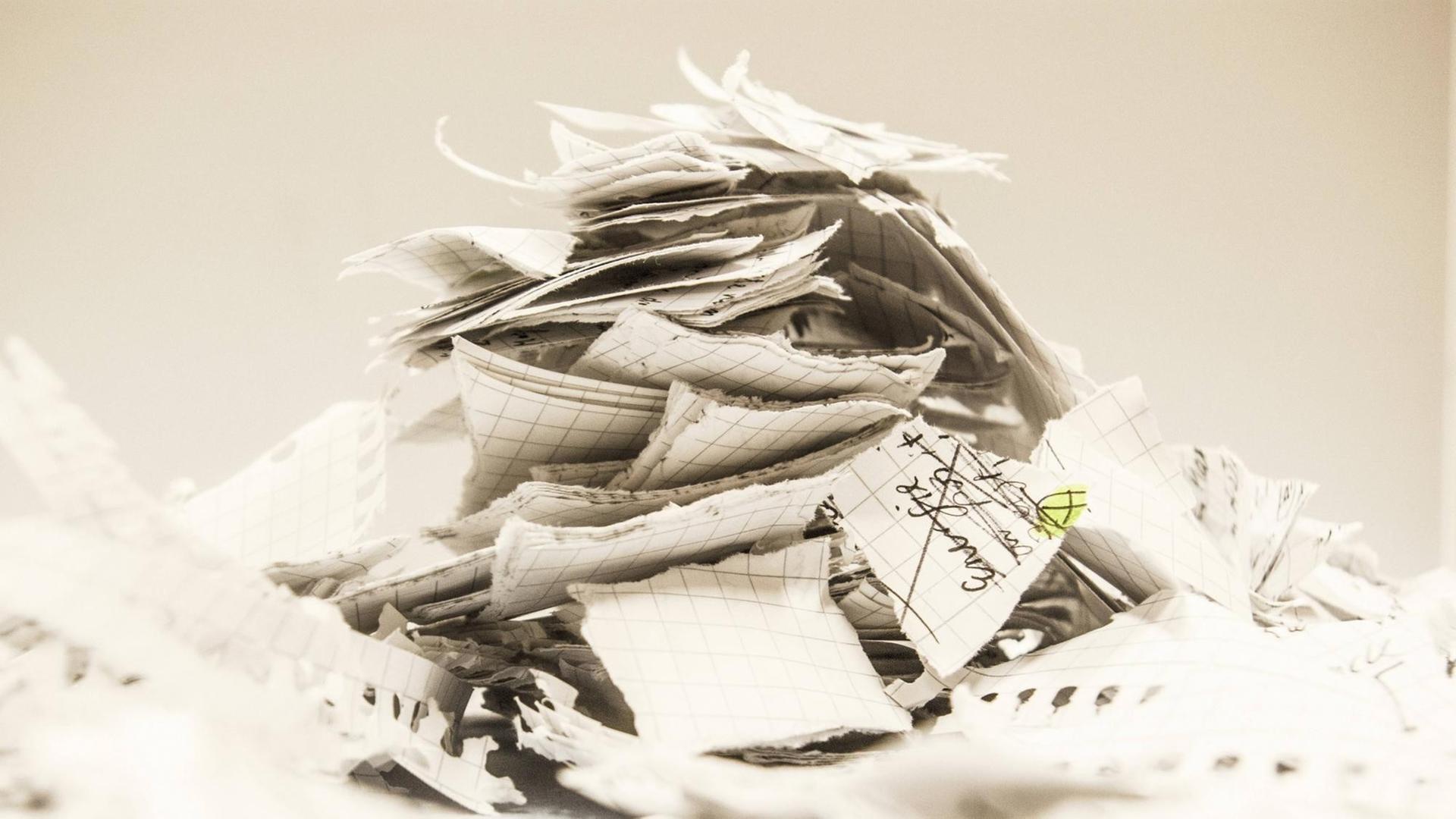 Ein Haufen von beschriebenen und zerissenen Papierschnipsel liegt übereinander. Ein Haufen von beschriebenen und zerissenen Papierschnipsel liegt übereinander.
