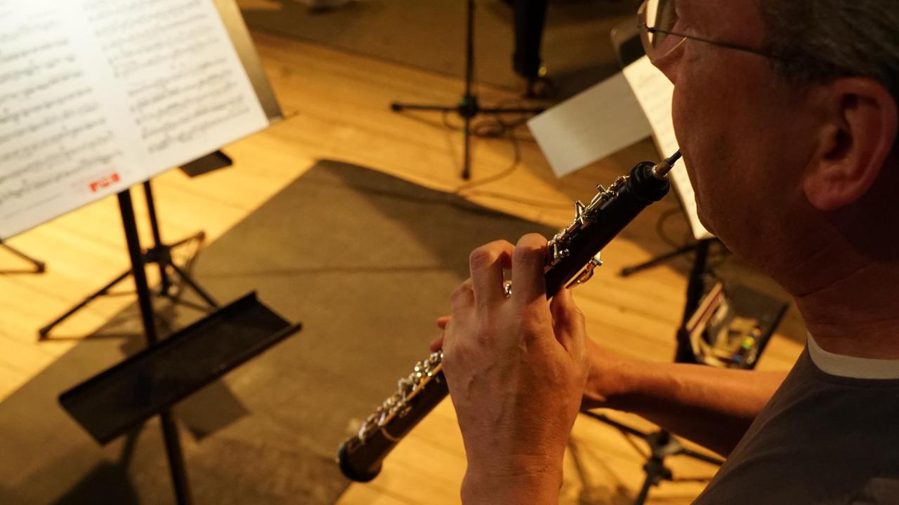 Blick über die Schulter des Oboisten, der konzentriert spielt. Blick über die Schulter des Oboisten, der konzentriert spielt.