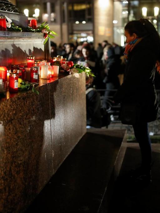 Menschen in Hanau zünden Kerzen an und legen Blumen nieder.