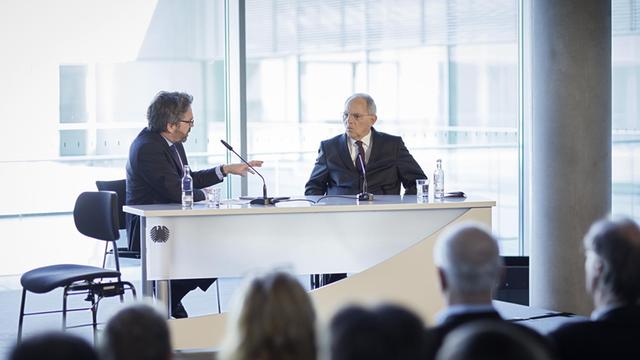 Stephan Detjen und Wolfgang Schäuble sitzen an einem Tisch vor Publikum