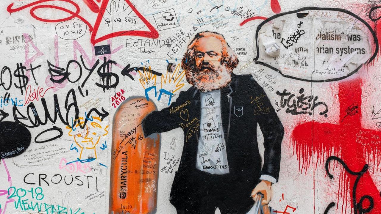 Eine Street-Art-Karikatur an einer Wand zeigt Karl Marx als Flaschensammler, der in einem Mülleimer wühlt. Eine Street-Art-Karikatur an einer Wand zeigt Karl Marx als Flaschensammler, der in einem Mülleimer wühlt.