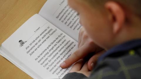 Ein Schüler der vierten Klasse liest am in seinem Lesebuch.