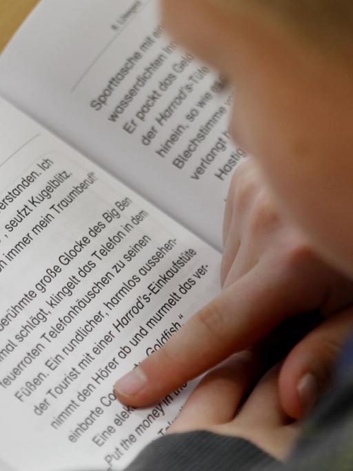 Ein Schüler der vierten Klasse liest am in seinem Lesebuch.