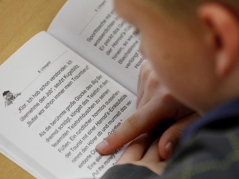 Ein Schüler der vierten Klasse liest am in seinem Lesebuch.