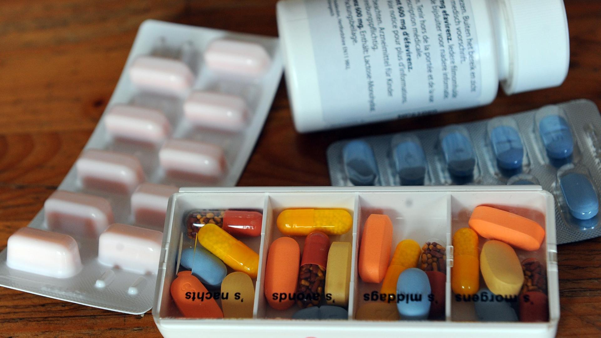 Tabletten liegen in Tagesrationen und in Blistern auf einem Tisch. Tabletten liegen in Tagesrationen und in Blistern auf einem Tisch.