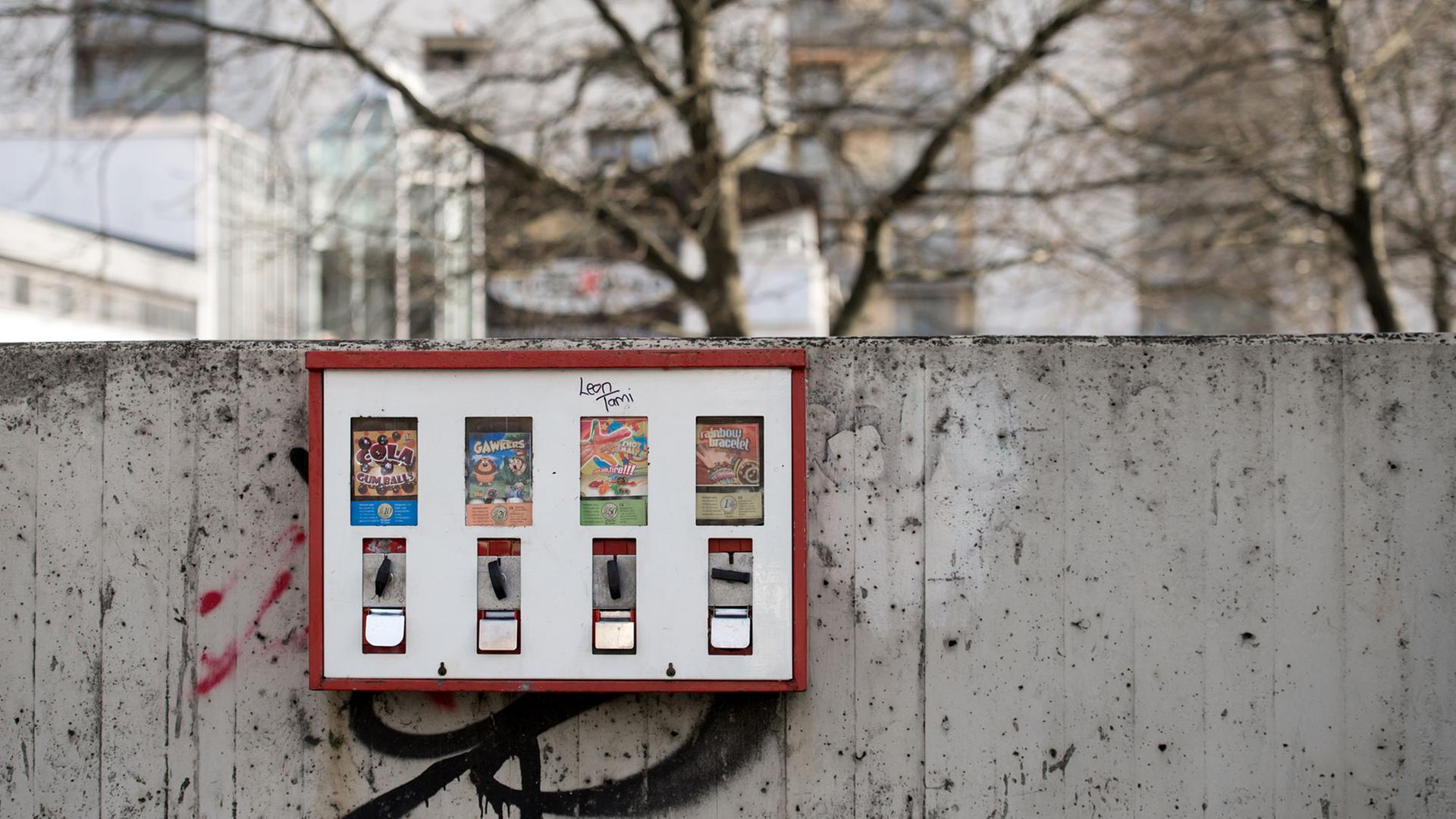 Ein Kaugummiautomat hängt im Münchner Stadtteil Westkreuz (Bayern) an einer Mauer.
