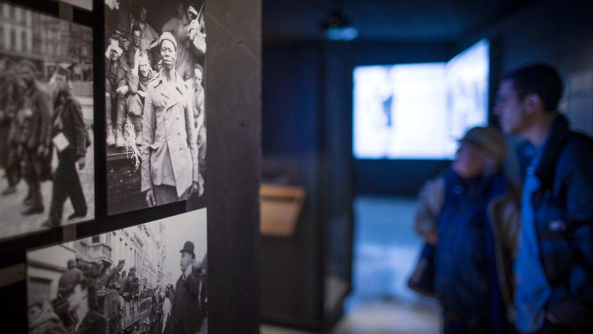 Fotos im 2015 eröffneten Memorial Museum in der Kulturhauptstadt Mons, die einen französischen Soldaten im Zweiten Weltkrieg zeigen. Im Hintergrund sind Videoleinwände zu sehen.