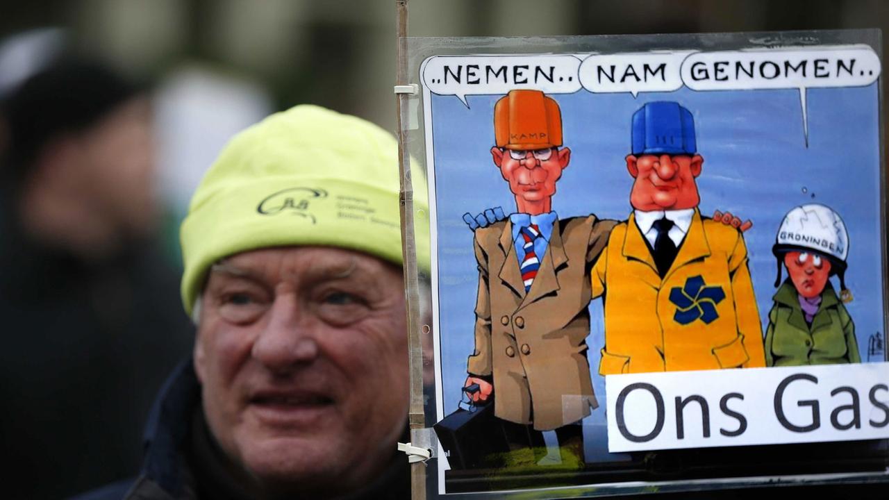 Ein Demonstrant gegen die Erdgasförderung in Loppersum hält ein Schild hoch mit der Aufschrift "Take, took, taken our gas" Ein Demonstrant gegen die Erdgasförderung in Loppersum hält ein Schild hoch mit der Aufschrift "Take, took, taken our gas"