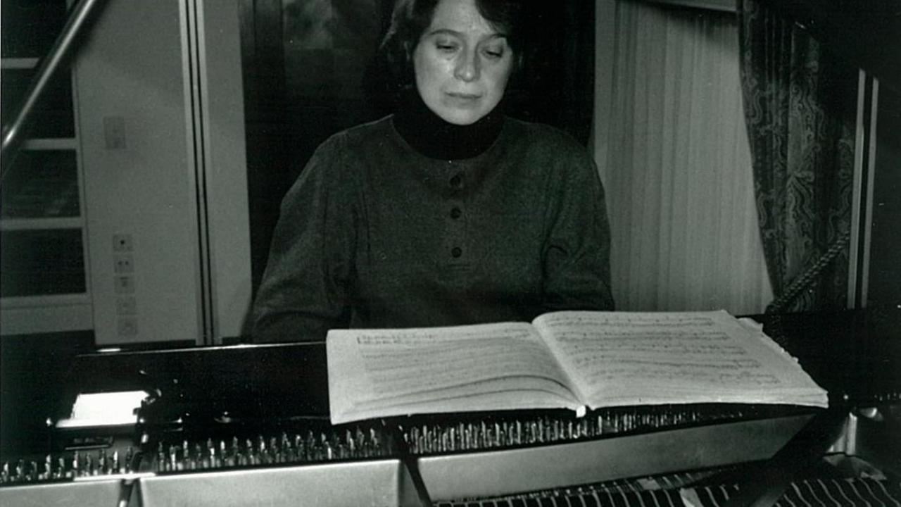 Eine Pianistin sitzt im häuslichen Umfeld an einem großen Konzertflügel und übt. Eine Pianistin sitzt im häuslichen Umfeld an einem großen Konzertflügel und übt.