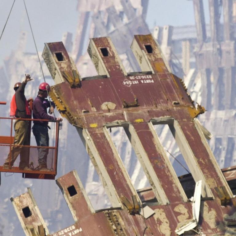 Arbeiter auf einer Hebebühne entwirren am 15. September 2001 die Überbleibsel des eingestürzten World Trade Centers in New York.