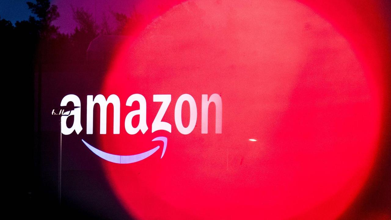 Amazonlogo im roten Licht: Sortierzentrum vom Onlineversandhändler Amazon Logistics in Schönefeld. Amazonlogo im roten Licht: Sortierzentrum vom Onlineversandhändler Amazon Logistics in Schönefeld.