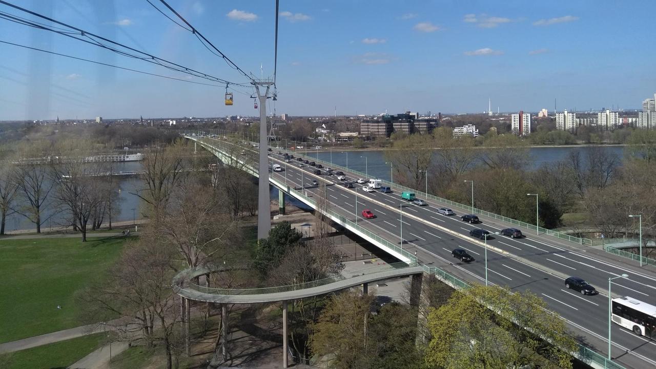 Aufnahme der Kölner Zoobrücke mit Autos, die über die Brücke fahren, darüber schwebt die Seilbahn. Aufnahme der Kölner Zoobrücke mit Autos, die über die Brücke fahren, darüber schwebt die Seilbahn.