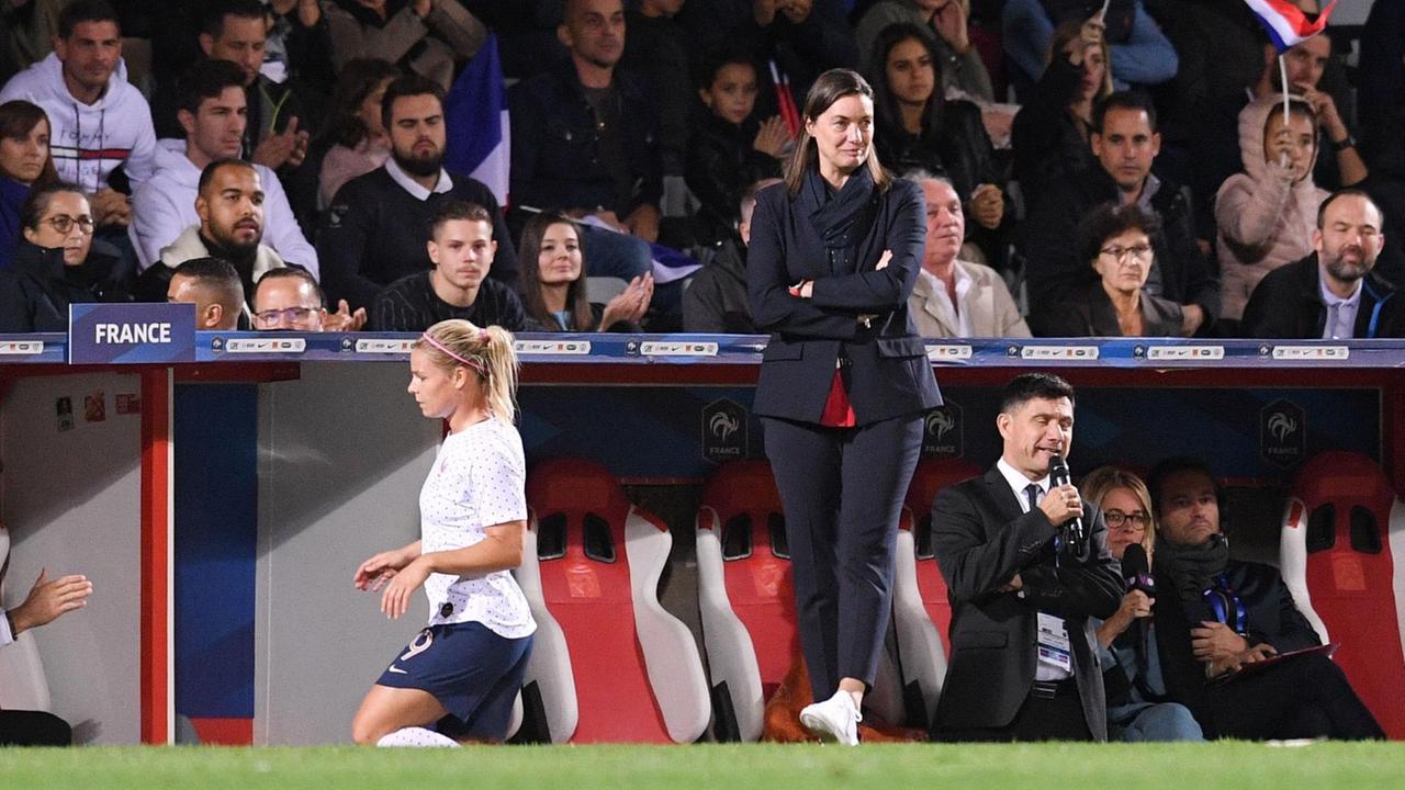 Corinne Diacre,Trainerin der französischen Frauen-Nationalmannschaft, bei Spiel Frankreich gegen Island im Oktober 2019. Eine Frau steht am Spielfeldrand.