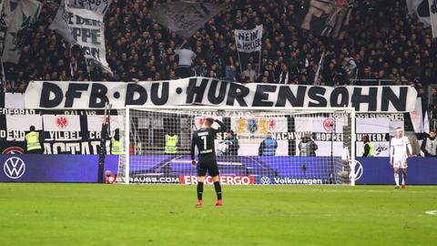 Fußballfans halten im Stadion ein Transparent auf dem steht: "DFB Du Hurensohn".