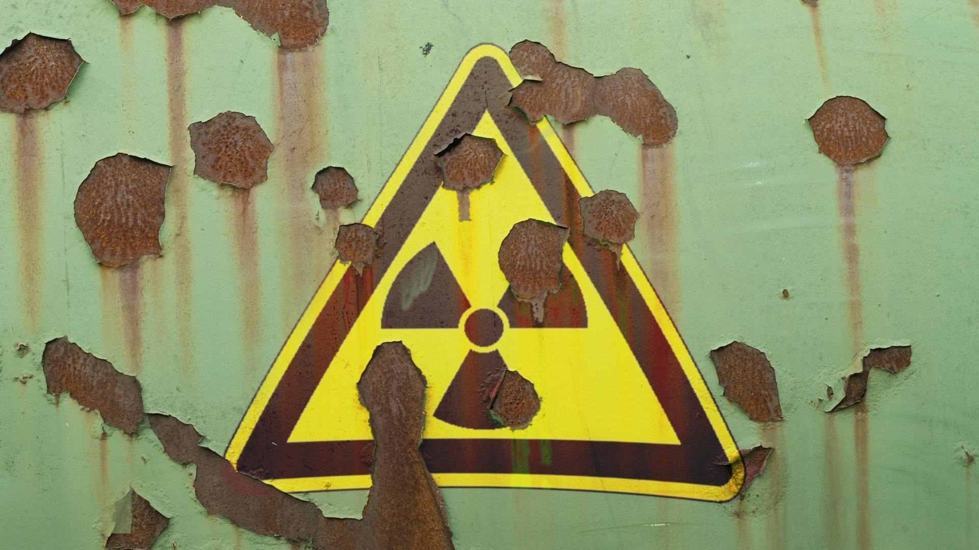 Abblätterndes Hinweisschild auf Radioaktivität an einer Mauer Abblätterndes Hinweisschild auf Radioaktivität an einer Mauer