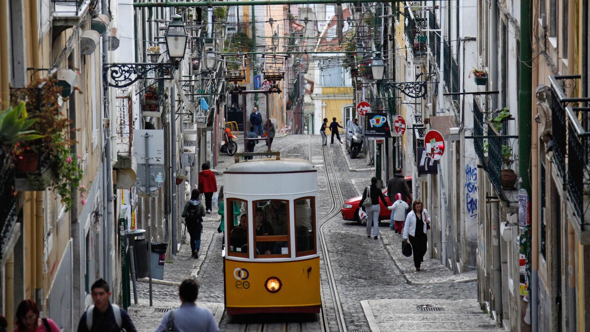 Die Standseilbahn "Ascensor da Bica" fährt durch eine Gasse in Lissabon. Die Standseilbahn "Ascensor da Bica" fährt durch eine Gasse in Lissabon.