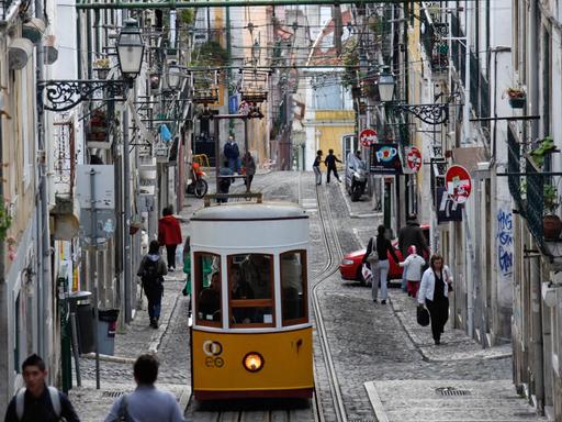 Die Standseilbahn "Ascensor da Bica" fährt durch eine Gasse in Lissabon.