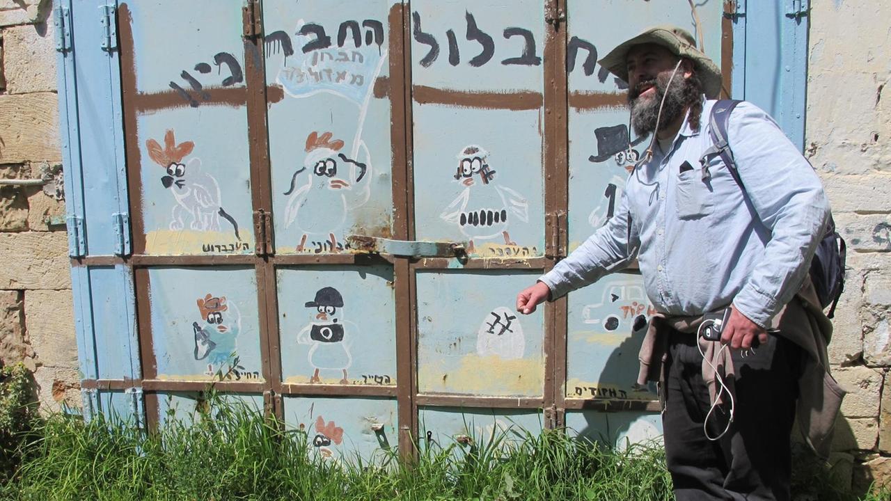 Mann mit Cowboyhut, halbnah aufgenommen, vor einer Mauerwand Mann mit Cowboyhut, halbnah aufgenommen, vor einer Mauerwand