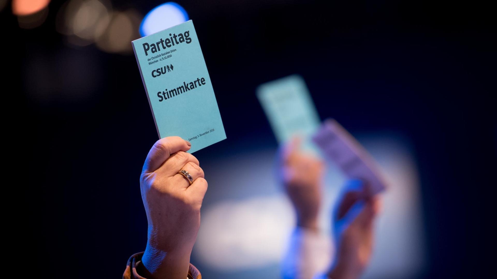 Die Teilnehmer beim CSU-Parteitag stimmen über das neue Grundsatzprogramm ab. Zu sehen sind Hände, die Stimmkarten in die Höhe halten. Die Teilnehmer beim CSU-Parteitag stimmen über das neue Grundsatzprogramm ab. Zu sehen sind Hände, die Stimmkarten in die Höhe halten.