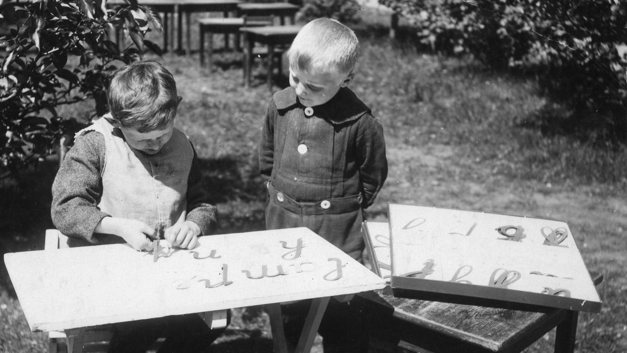 Durch Zusammensetzen ausgeschnittener Buchstaben lernen die Kinder die Schriftzeichen kennen.