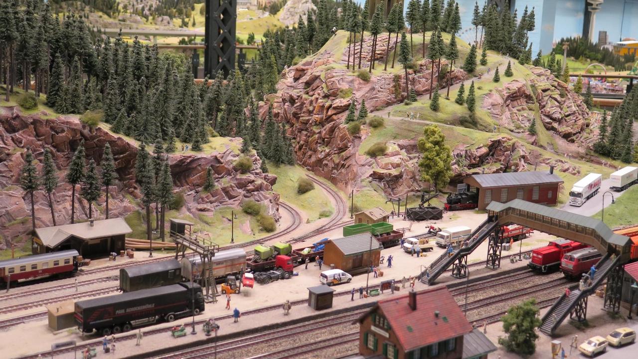 Eine Ansicht aus dem Miniatur-Wunderland, bei dem ebenfalls Züge die Landschaft durchqueren.
