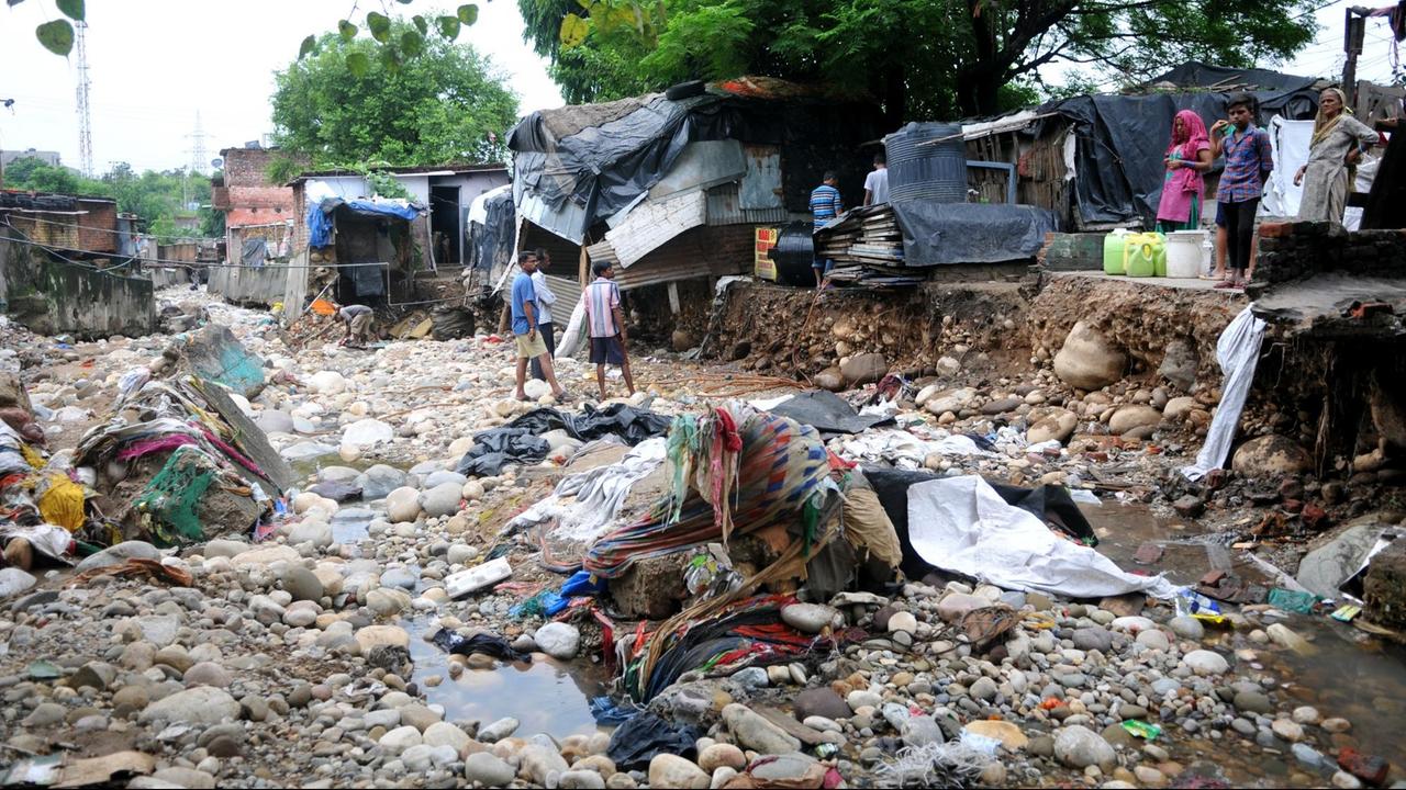 Anwohner stehen nach einer Sturzflut vor den Überresten ihrer beschädigten Häuser. Starke Regenfälle haben Erdrutsche ausgelöst und sind eine Bedrohung für viele Dörfer in der Nähe von Flüssen in der Region Jammu. Anwohner stehen nach einer Sturzflut vor den Überresten ihrer beschädigten Häuser. Starke Regenfälle haben Erdrutsche ausgelöst und sind eine Bedrohung für viele Dörfer in der Nähe von Flüssen in der Region Jammu.