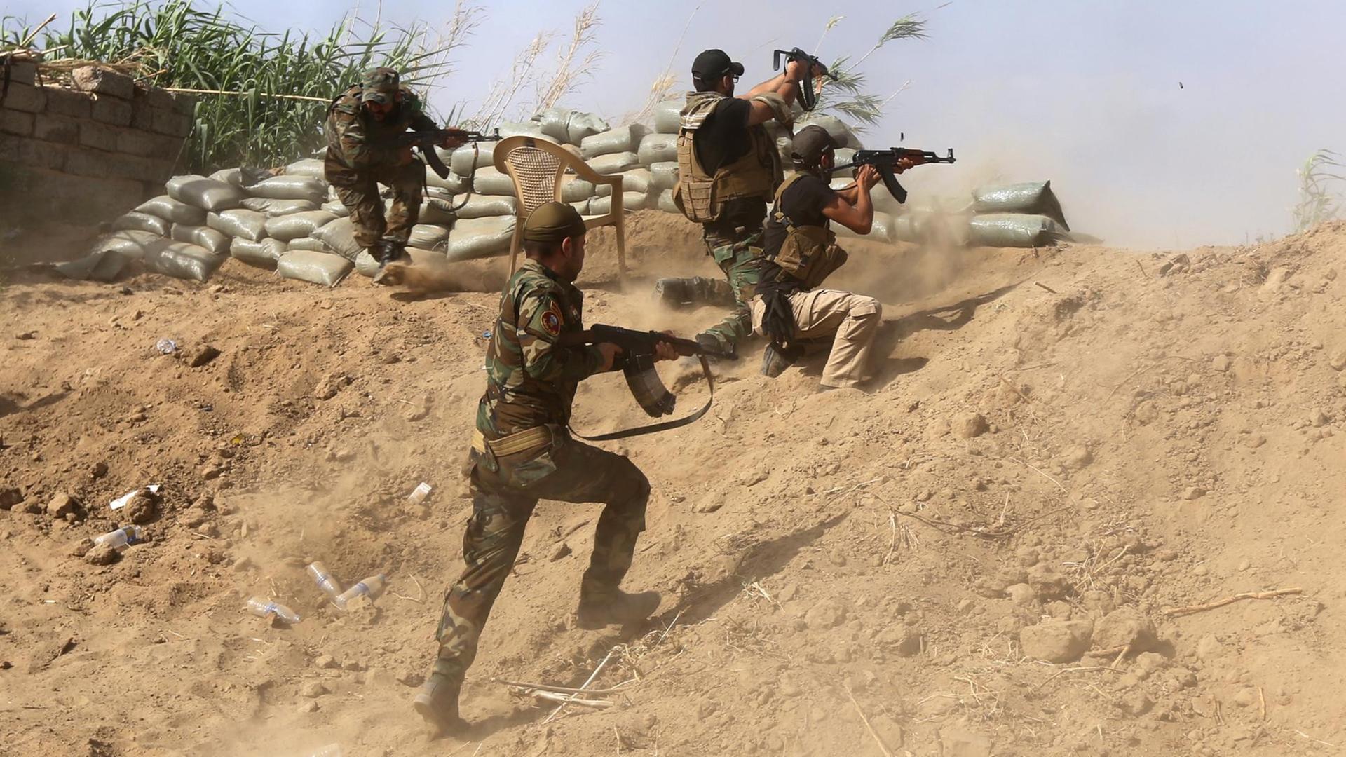 Sunnitische Kämpfer im Irak kämpfen mit Regierungstruppen nahe einer Ölraffinerie etwa 200 Kilometer nördlich von Bagdad. Sunnitische Kämpfer im Irak kämpfen mit Regierungstruppen nahe einer Ölraffinerie etwa 200 Kilometer nördlich von Bagdad.