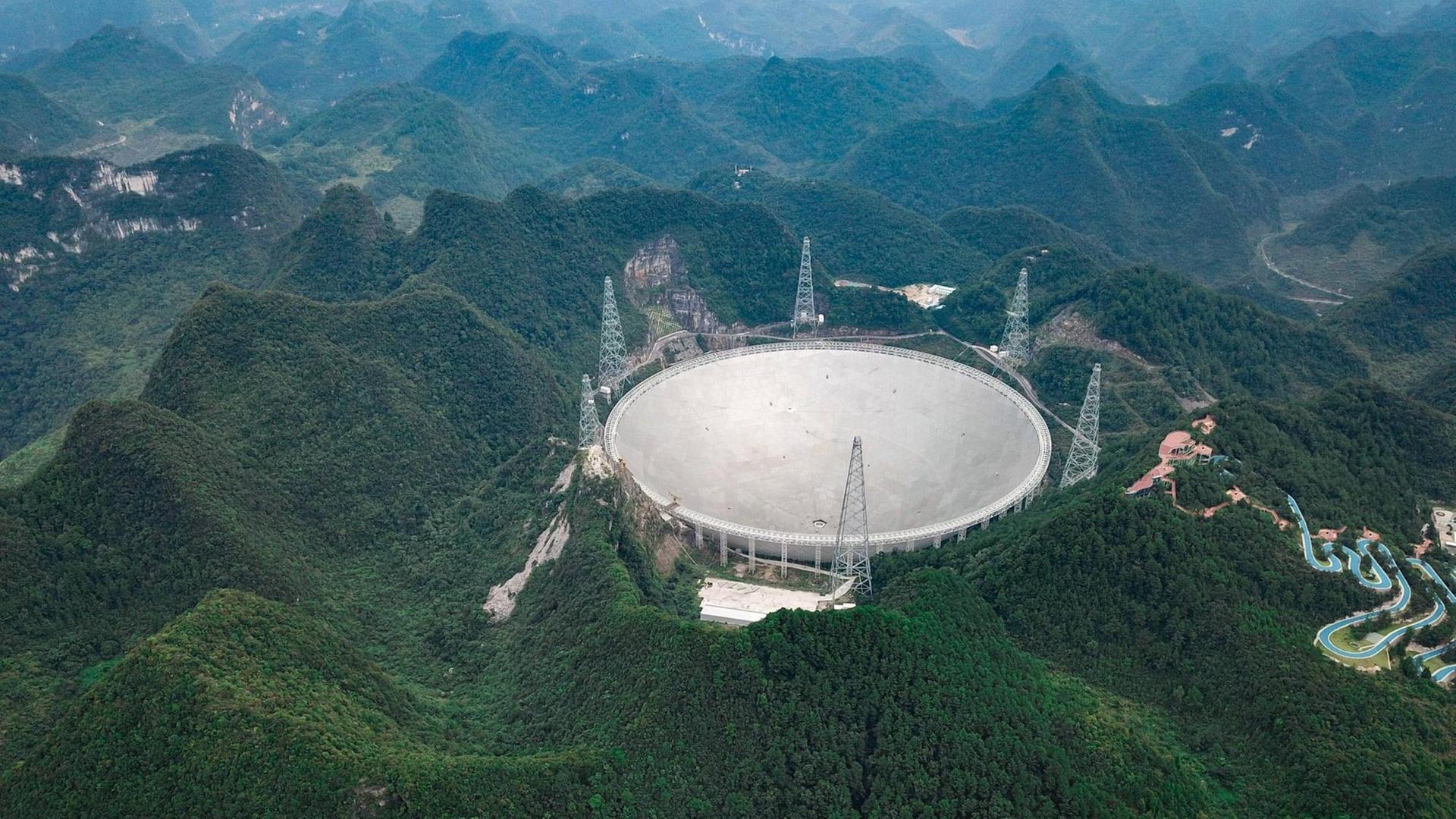 Mit einem Durchmesser von mehr als 500 Metern ist das kreisrunde Observatorium FAST in der Bergregion der südwestlichen Provinz Guizhou in China das größte Radioteleskop der Welt