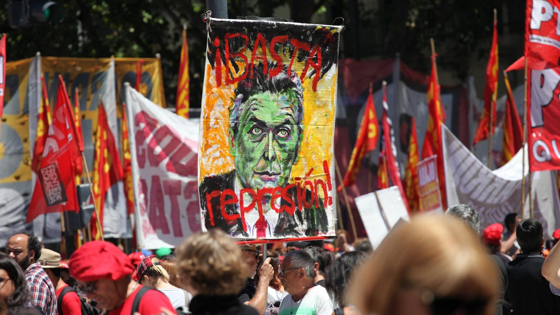 Ein Demonstrant hält in Buenos Aires (Argentinien) bei einem Protest ein Bild von Präsident Macri mit der Aufschrift "Stoppt die Polizei Unterdrückung!" hoch. Ein Demonstrant hält in Buenos Aires (Argentinien) bei einem Protest ein Bild von Präsident Macri mit der Aufschrift "Stoppt die Polizei Unterdrückung!" hoch.