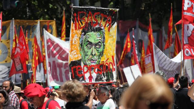 Ein Demonstrant hält in Buenos Aires (Argentinien) bei einem Protest ein Bild von Präsident Macri mit der Aufschrift "Stoppt die Polizei Unterdrückung!" hoch.