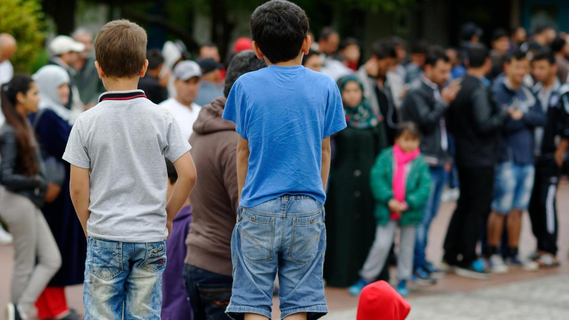 Flüchtlinge stehen am 25.08.2015 im Erstaufnahmelager für Flüchtlinge in Friedland (Niedersachsen). Das eigentlich für rund 700 Menschen konzipierte Lager im Landkreis Göttingen ist zur Zeit mit mehr als 3000 Menschen belegt.