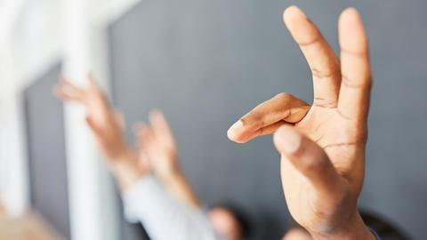 Hände von Menschen in einem Seminar oder einem Workshop