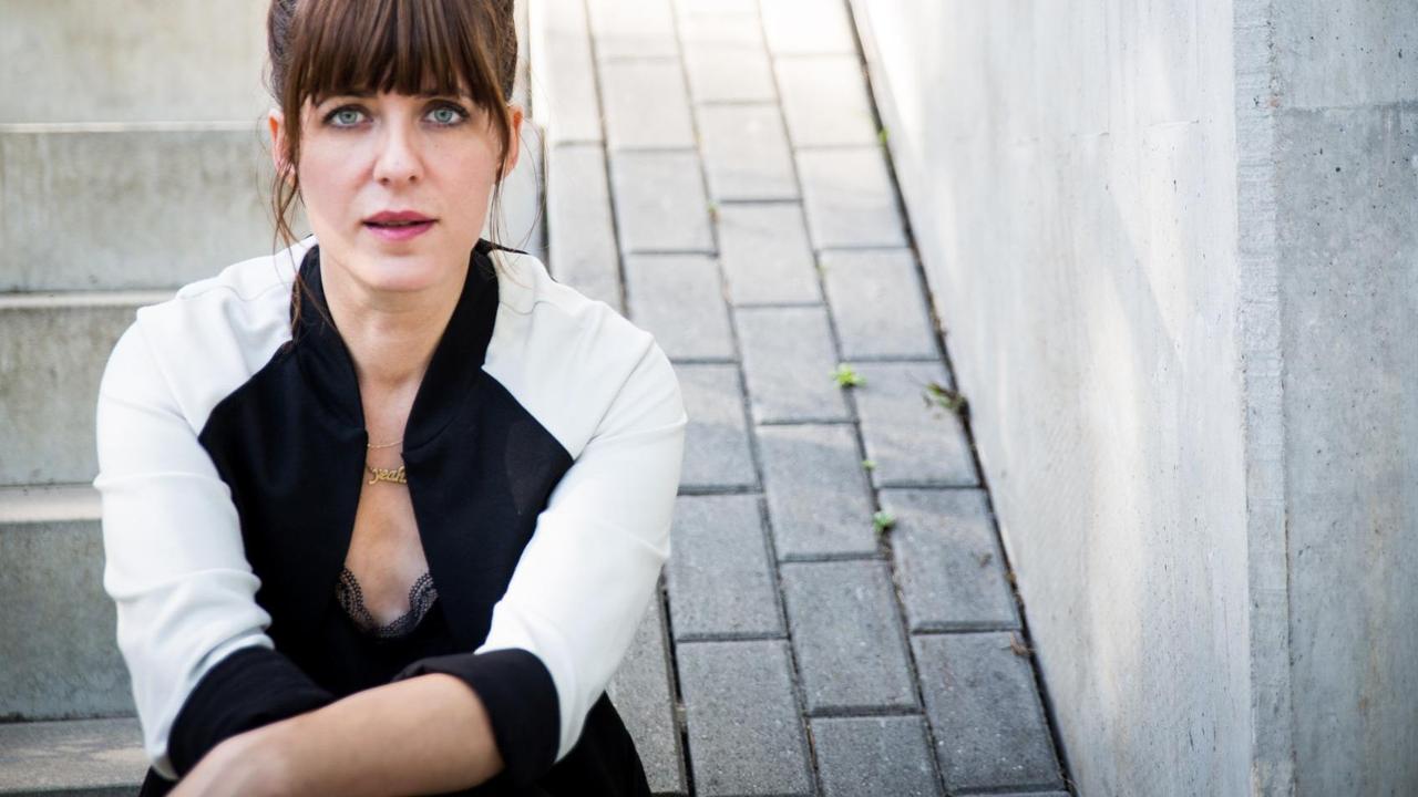 Sarah Kuttner sitzt auf einer Treppe und schaut in die Kamera. Sarah Kuttner sitzt auf einer Treppe und schaut in die Kamera.