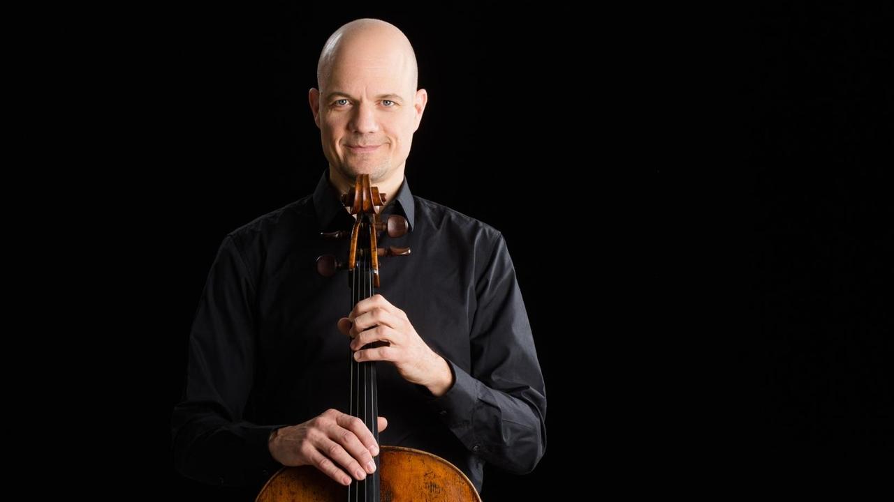 Der Cellist hält sein Instrument vor sich und stützt sein Kinn darauf. Der Cellist hält sein Instrument vor sich und stützt sein Kinn darauf.